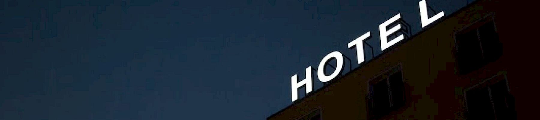 A building with the word "HOTEL" on top against a dark sky.