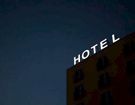 A building with the word "HOTEL" on top against a dark sky.